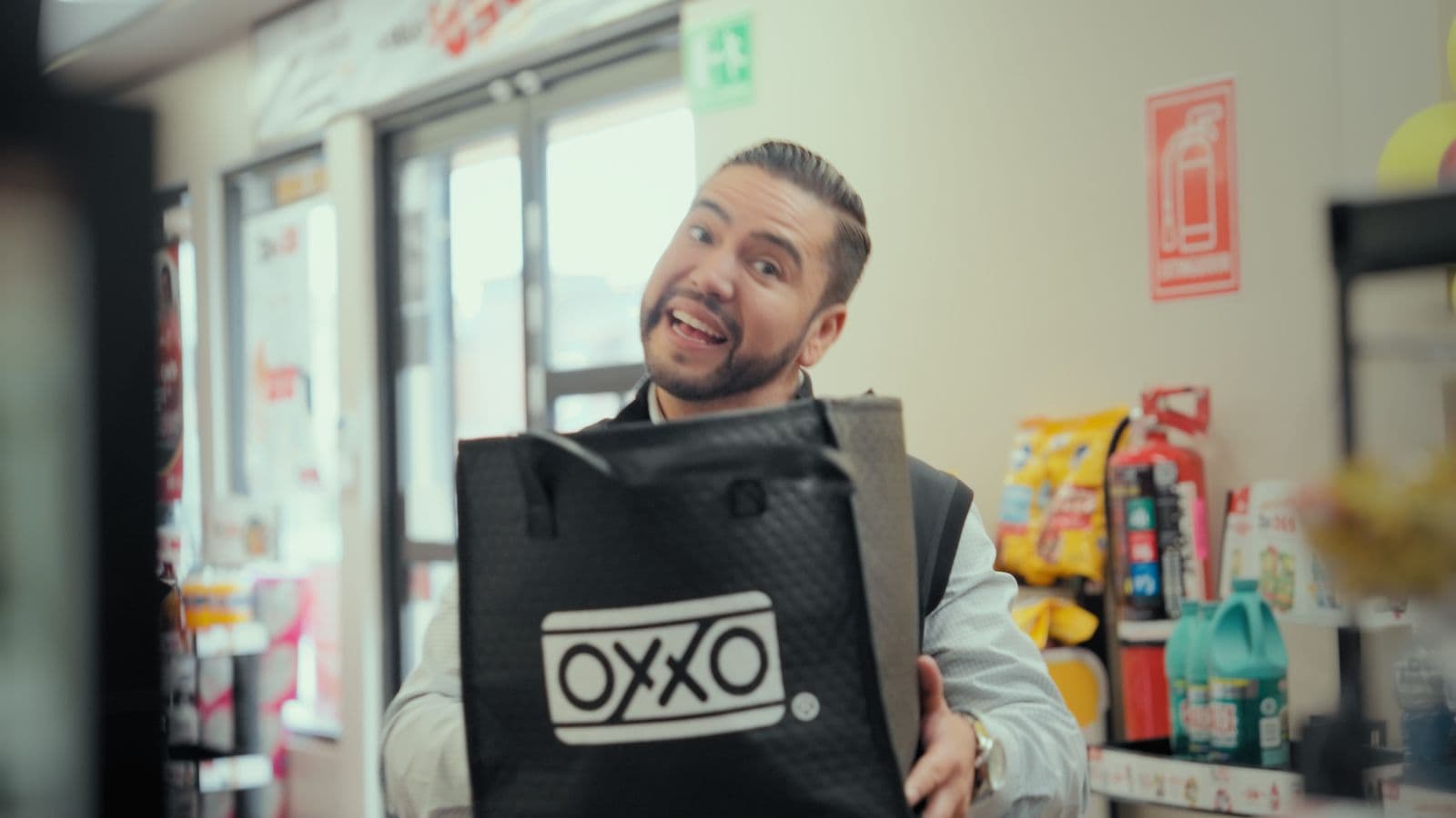 Cliente mostrando su bolsa de OXXO en el comercial de Helados Gonfra