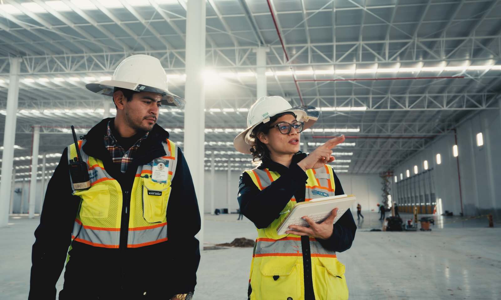 Supervisores con equipo de protección personal en nave industrial