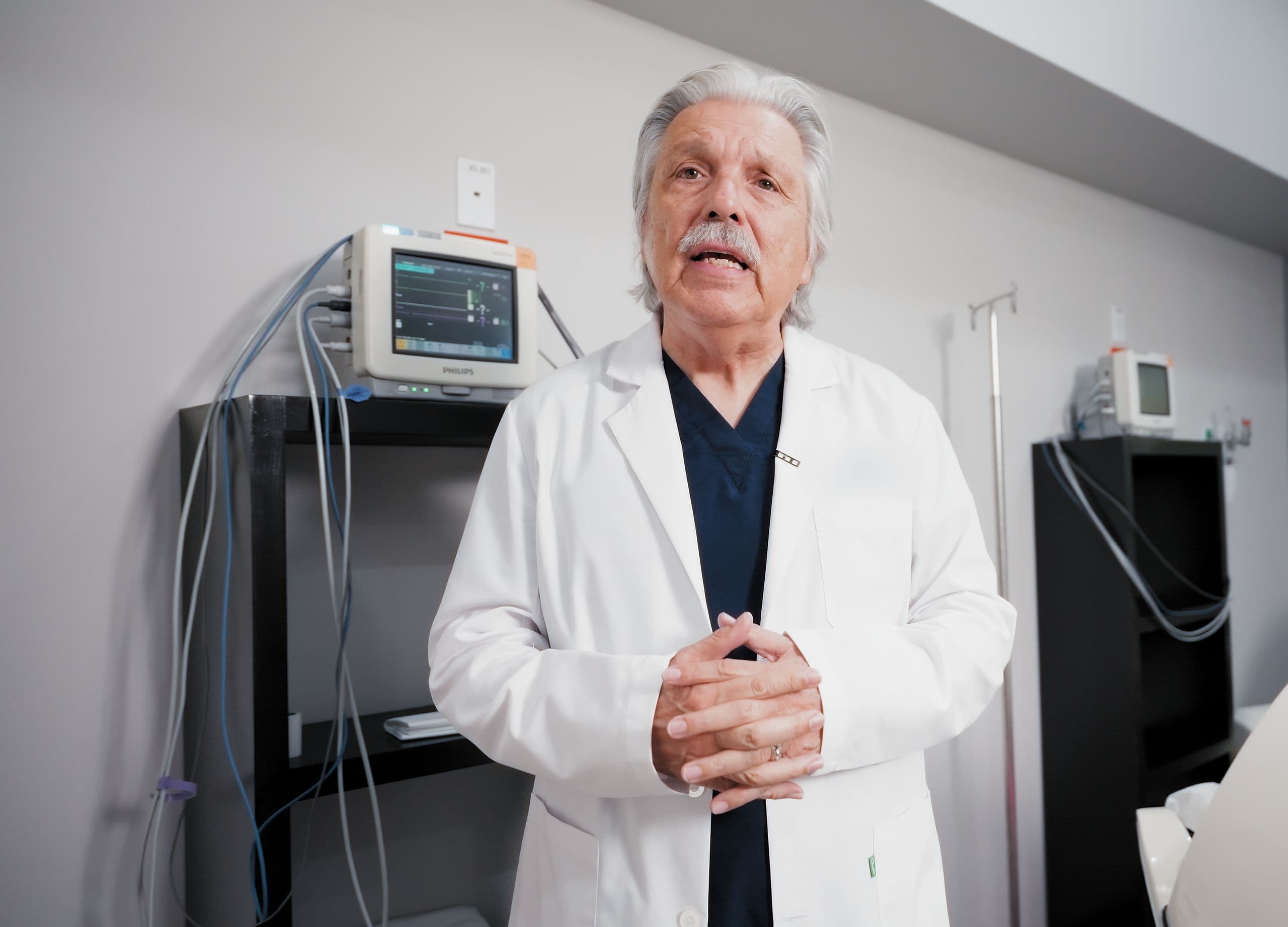 Médico especialista hablando a cámara en una sala de tratamiento